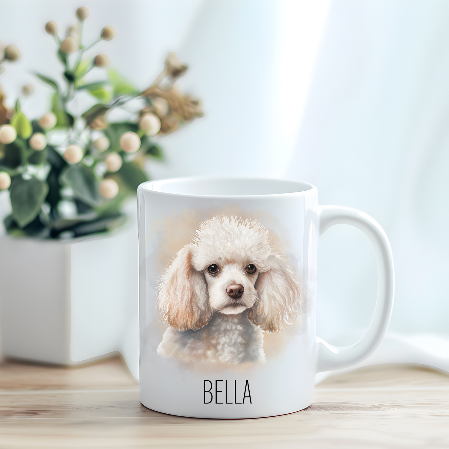 This coffee mug features a cute white poodle on a white ceramic mug which has been placed on a light wooden surface.  A green and white plant sits on the left side of the image in a square plant pot.