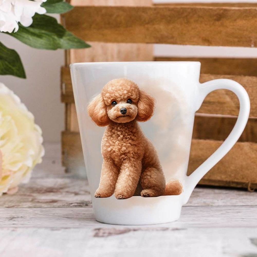 A white ceramic latte mug stands on a wooden surface with a crate in the background. The mug features an Apricot Miniature Poodle.  A large yellow flower peeps in from the left-hand side.
