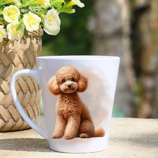 A white ceramic latte mug featuring an Apricot Miniature Poodle in a gold/beige mist background.  A basket containing yellow flowers sits to the left-hand side.