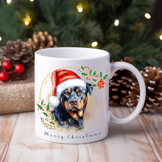 A ceramic mug with a watercolor design of a Rottweiler wearing a Santa hat, surrounded by Christmas-themed decorations.