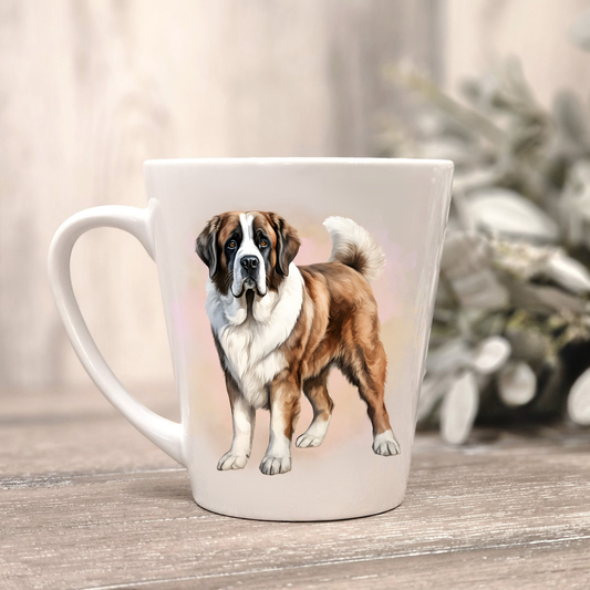 A Saint Bernard is shown in a standing position on a white ceramic latte mug in a smoky background and looking forward.  The mug is placed on a wooden surface with sage green foliage to the right-hand side.