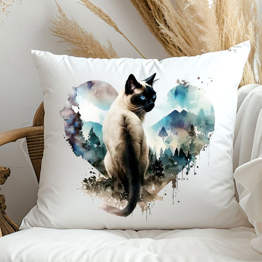 square white cushion showing a siamese cat looking backwards and situated within a blue heart depicting a mountain scene.