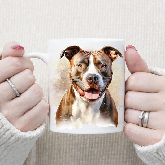 White ceramic mug with an image of a Brindle Staffordshire Bull Terrier with a white chest sat facing forward. A woman is holding the mug with both hands.