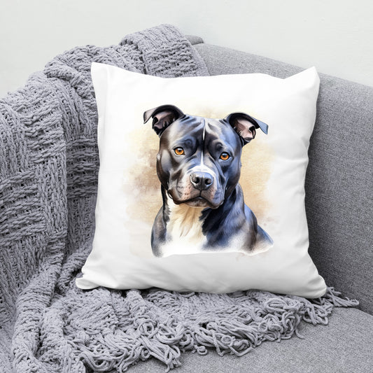 White sofa cushion with an image of a black Staffordshire Bull Terrier with a white chest sat gazing forward. The cushion is placed on a grey sofa with a grey blanket draped across the corner