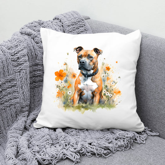 White sofa cushion with an image of a tan Staffordshire Bull Terrier with a white chest sat gazing left. The cushion is placed on a grey sofa with a grey blanket draped across the corner
