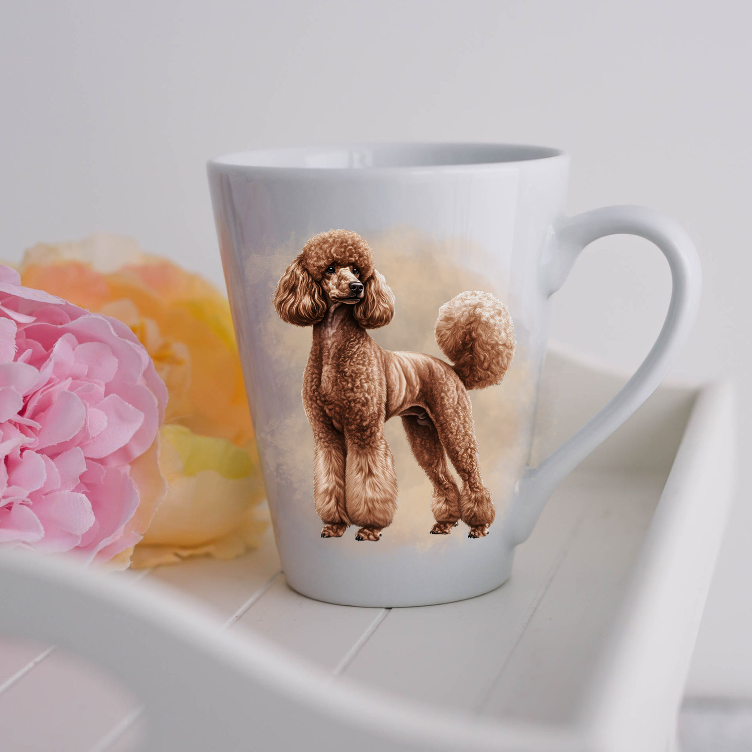 A brown Standard Poodle is standing and is placed on a white ceramic latte mug in a smoky background and looking to its left.  The mug is placed on a white tray with pink and yellow flowers.