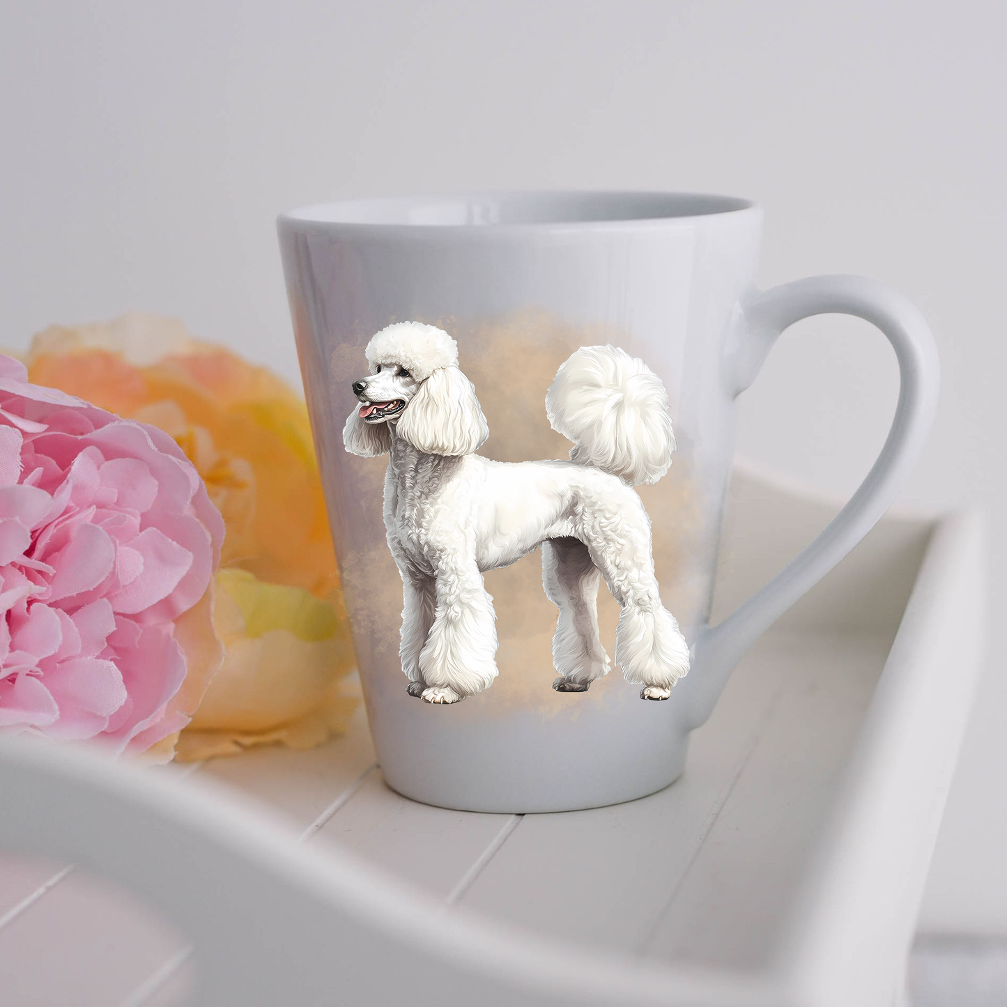 A white Standard Poodle is standing and is placed on a white ceramic latte mug in a smoky background and looking to its left.  The mug is placed on a white tray with pink and yellow flowers.
