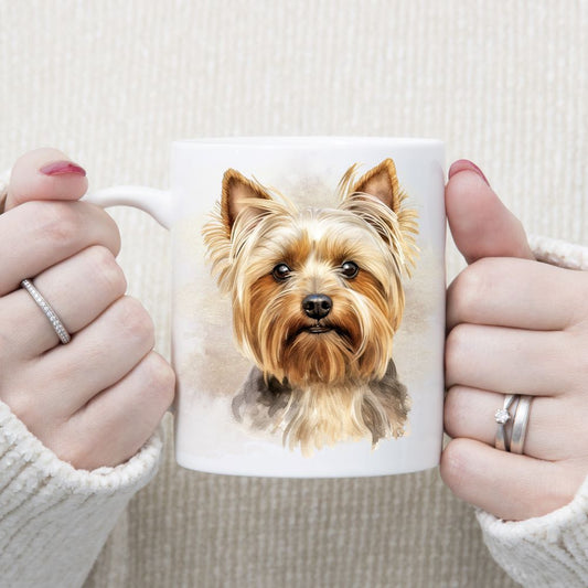 A head print of a Yorkshire Terrier dog on a white ceramic mug. The mug is being held by a woman with both hands.