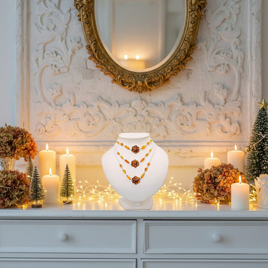Decorative setup with a necklace on a white stand, candles, and a mirror in an elegant room.