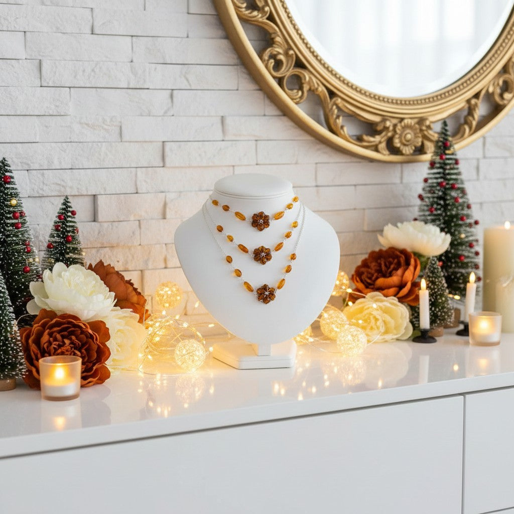 Jewellery display with necklaces on a mannequin against a decorative background with candles and small trees.