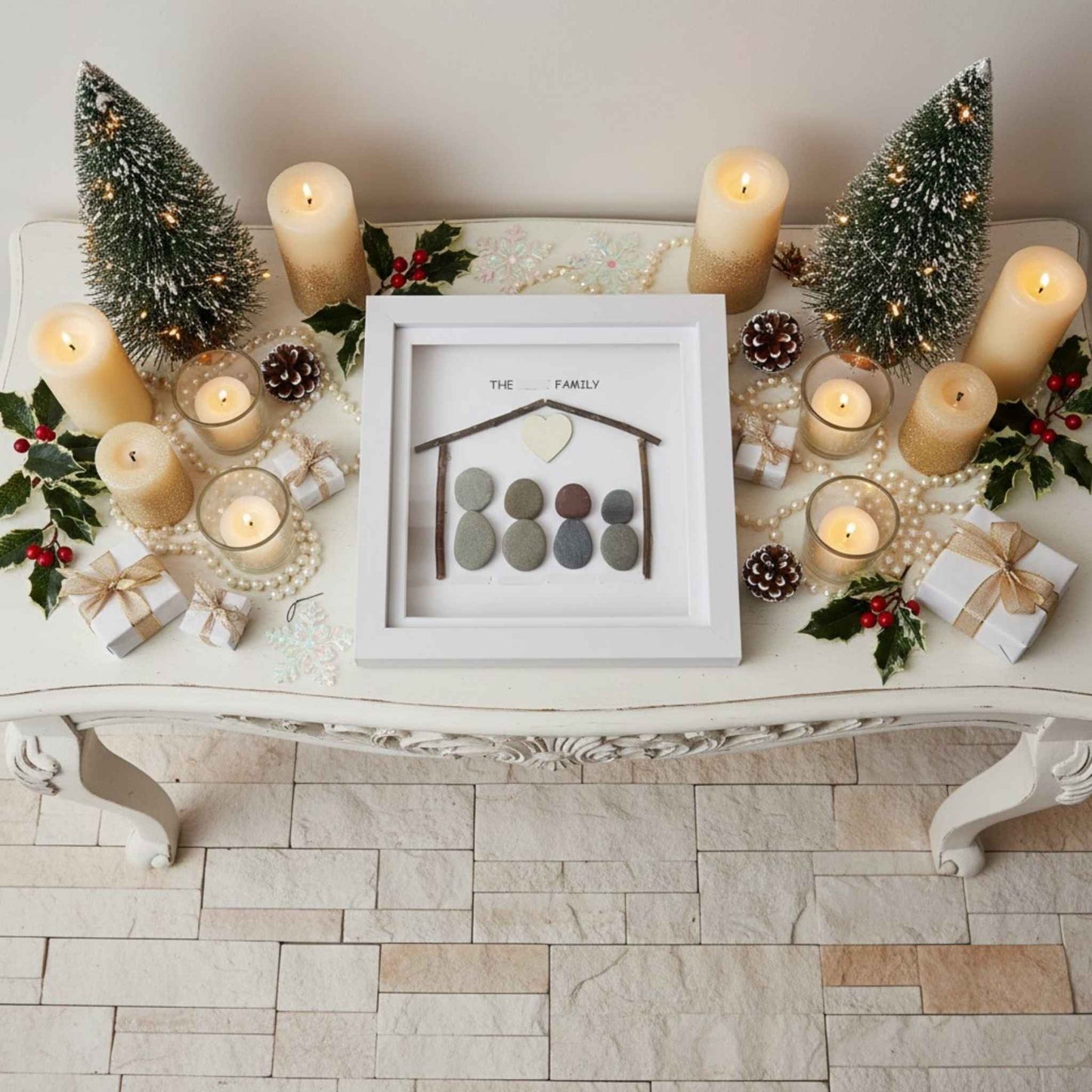 Decorative console setting with candles, small trees, and a family photo frame.