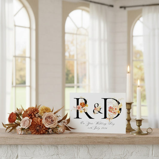 Decorative wedding card with floral designs and text on a table in a room with large windows.