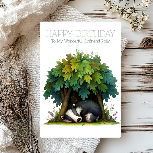 Birthday card with a badger under a tree, surrounded by natural elements on a wooden surface.
