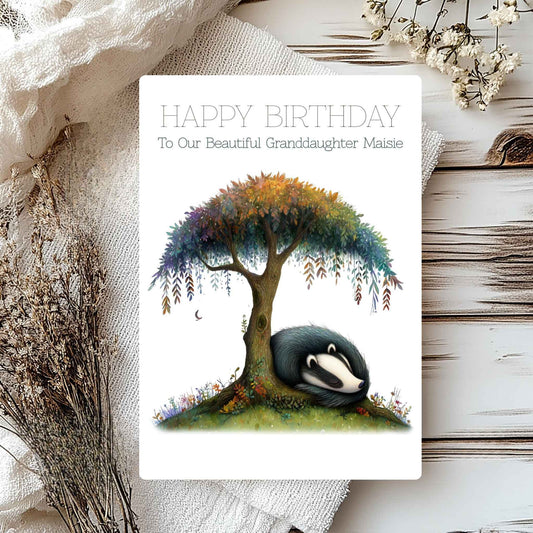 Birthday card with a badger under a tree, surrounded by flowers on a textured surface.