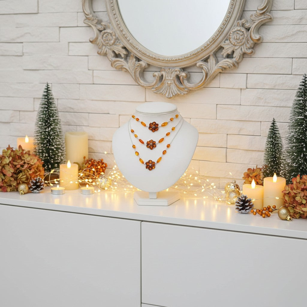 Necklace on a white stand with decorative candles and trees in the background
