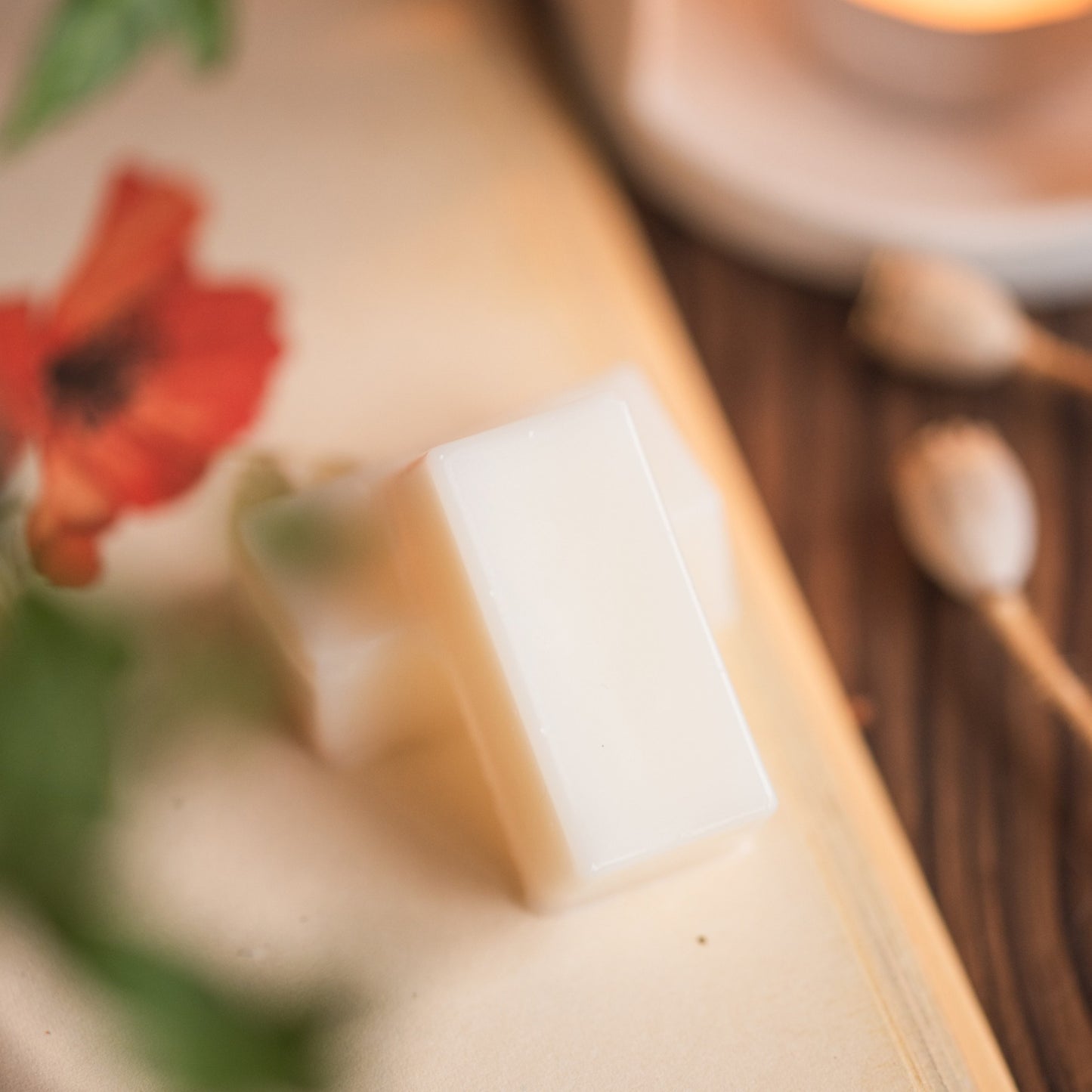 Close-up of a bar of wax melt piece on a wooden surface with a blurred background