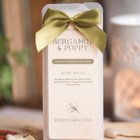 Product packaging with a green bow labeled 'Bergamot & Poppy' by 'Robins Whisper'.
