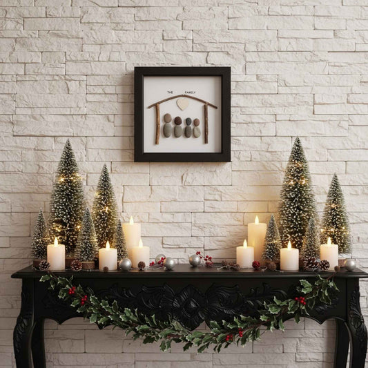 Pebble Art with decorative mantel with Christmas trees, candles, and a framed artwork on a stone wall.