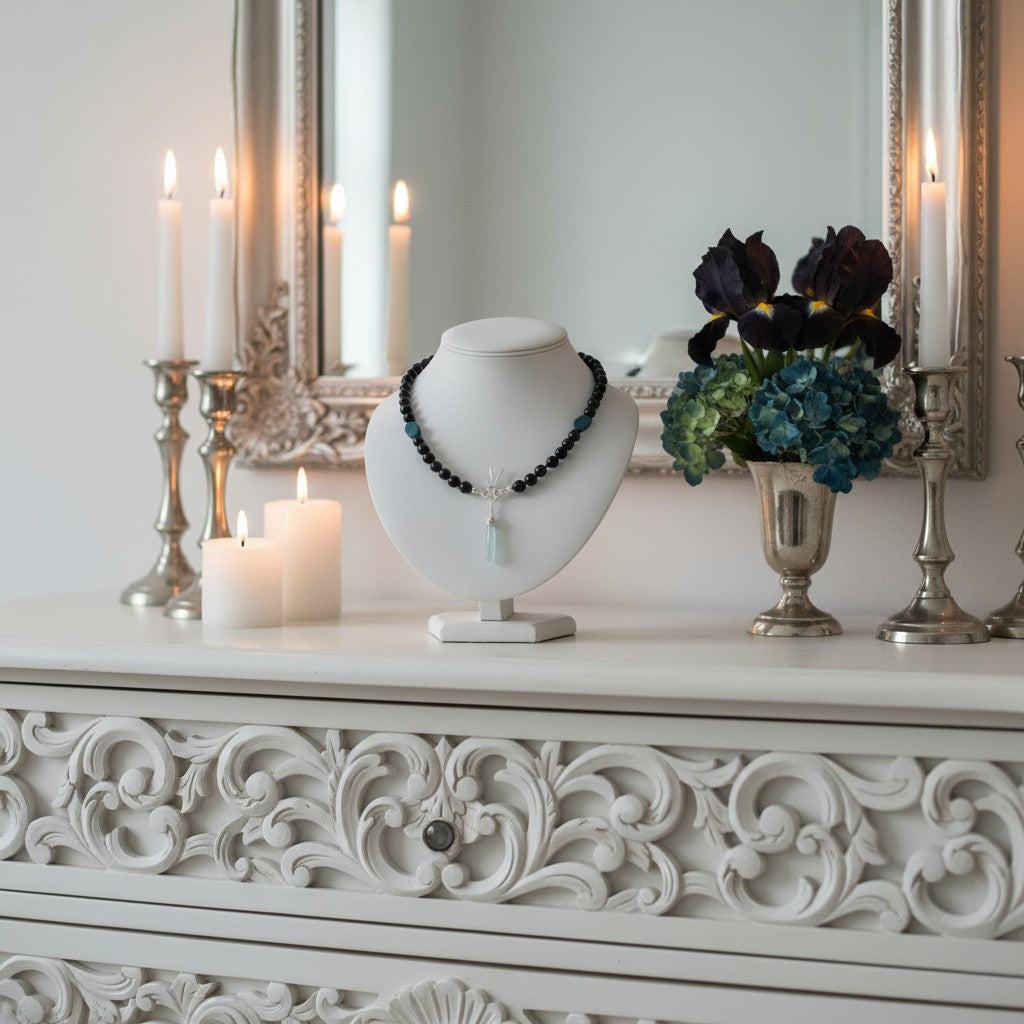 Pretty Gemstone Necklace on a mannequin bust with candles and flowers on a decorative table.
