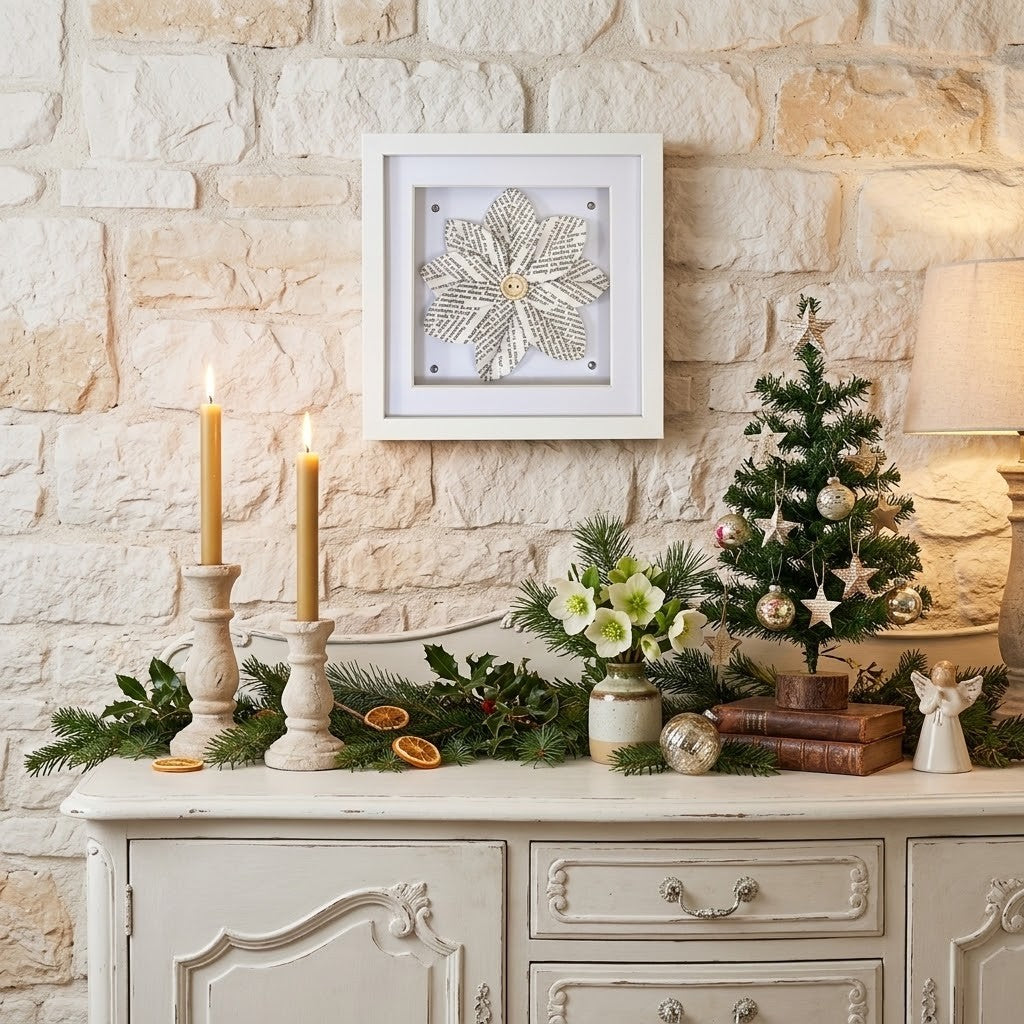 A framed reader gift piece is displayed on a rustic stone wall above a decorated Christmas console table with candles, a small tree, flowers, and books.