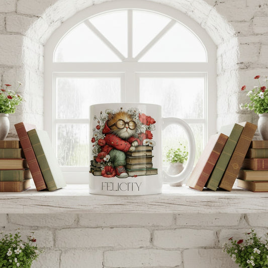 Ceramic mug with a cat design on a windowsill with books and flowers.