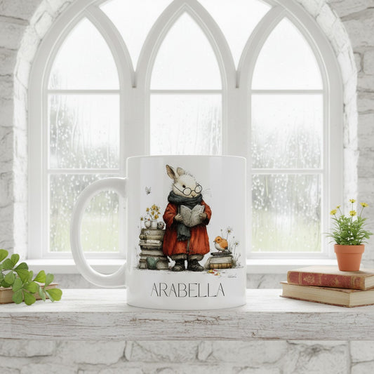 Decorative bookish hare mug with 'Arabella' on a windowsill with books and plants.