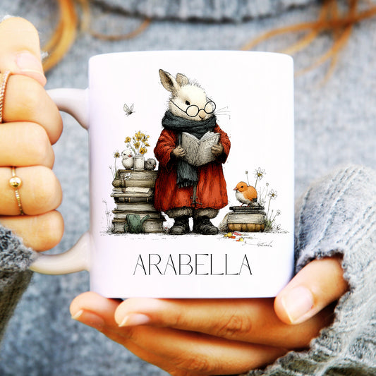 Person holding a bookish hare mug with a cartoon character and 'Arabella' text