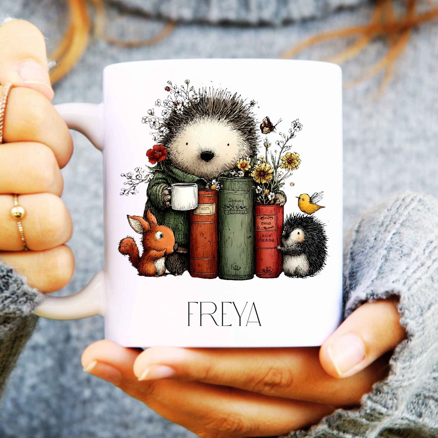 Person holding a mug with hedgehog design and 'FREYA' text