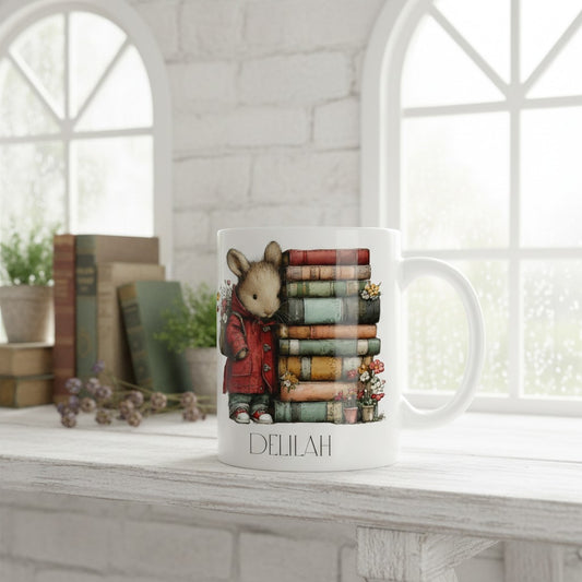 Mug with a design of a mouse in a red coat standing next to books on a white surface.