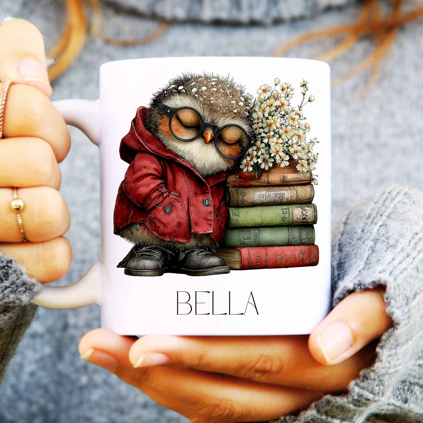 Person holding a mug with an owl design and the name 'Bella' on it.