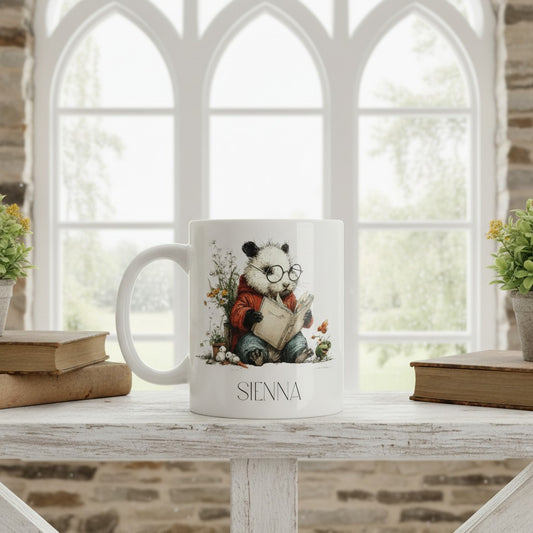 Mug with a panda design and 'SIENNA' branding on a table with books and plants.
