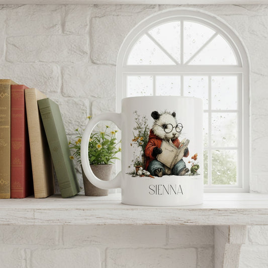 Mug with a design of a panda reading a book, placed on a shelf with books and a plant.