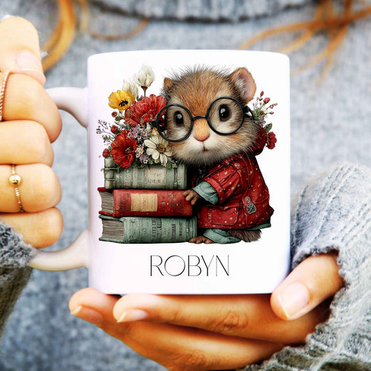 Mug with a design of a squirrel wearing glasses and holding books, held by a person.