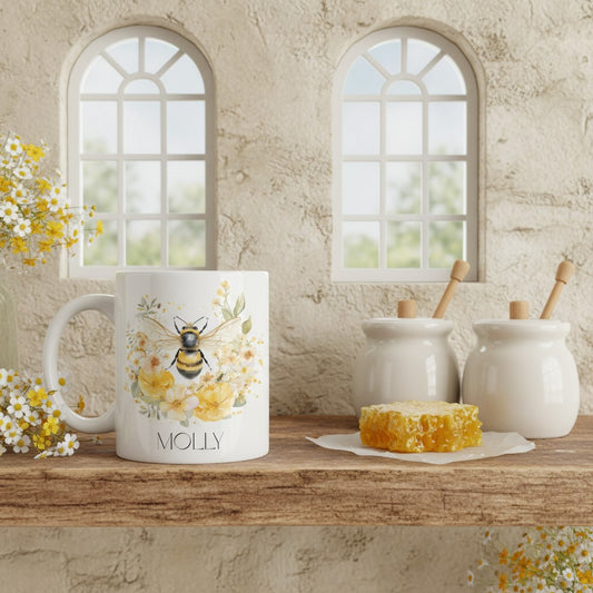 Mug with bee and floral design on a wooden surface with honeycomb and jars in a rustic setting.