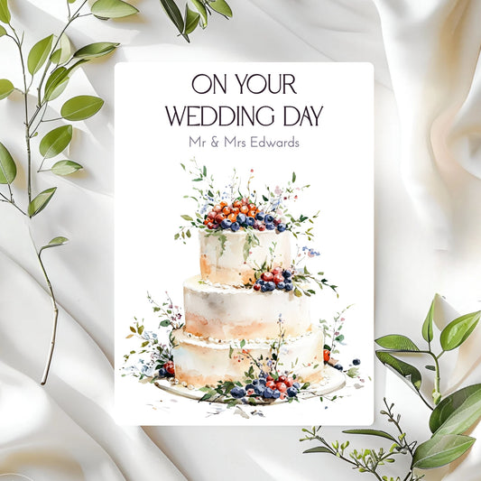 Wedding card with a cake illustration and 'On Your Wedding Day' text on a white background with green leaves.
