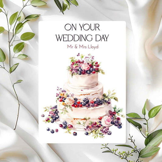 Wedding card with a cake illustration and 'On Your Wedding Day' text on a white background with green leaves.