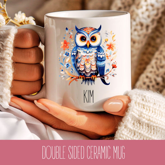 A ceramic mug with a double-sided design featuring a colourful owl illustration and the name 'Kim'.