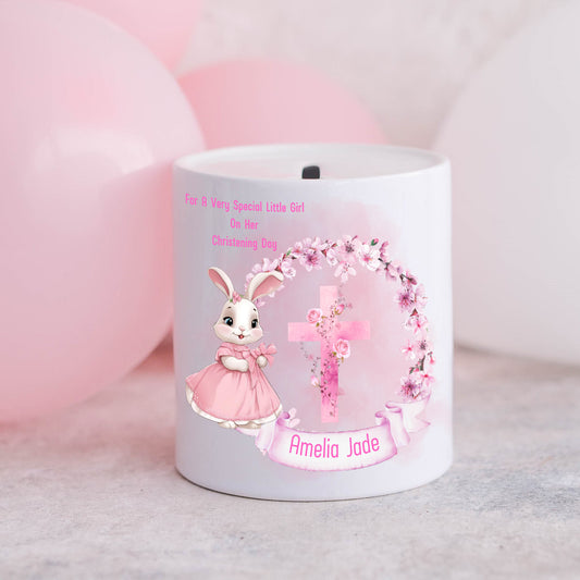 personalised christening money box for a girl with a rabbit, floral wreath and a cross