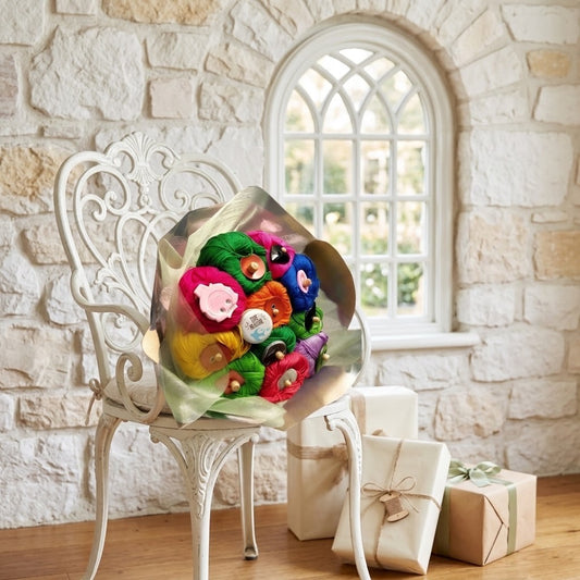 A colourful bouquet of knitting yarn sits on a white ornate chair in a stone room, with wrapped gift boxes on the floor nearby.