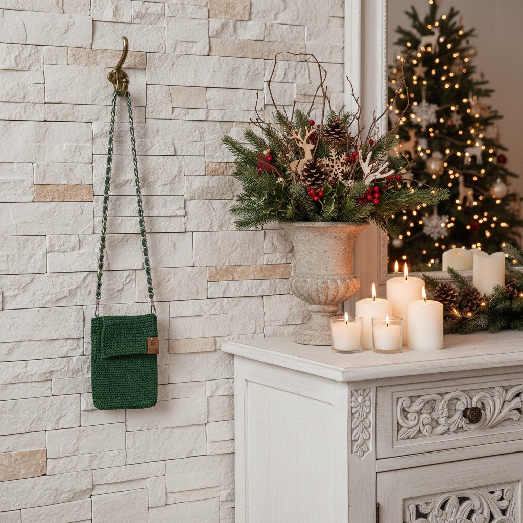 Decorative setting with a green bag, candles, and a Christmas tree in a room with stone walls.