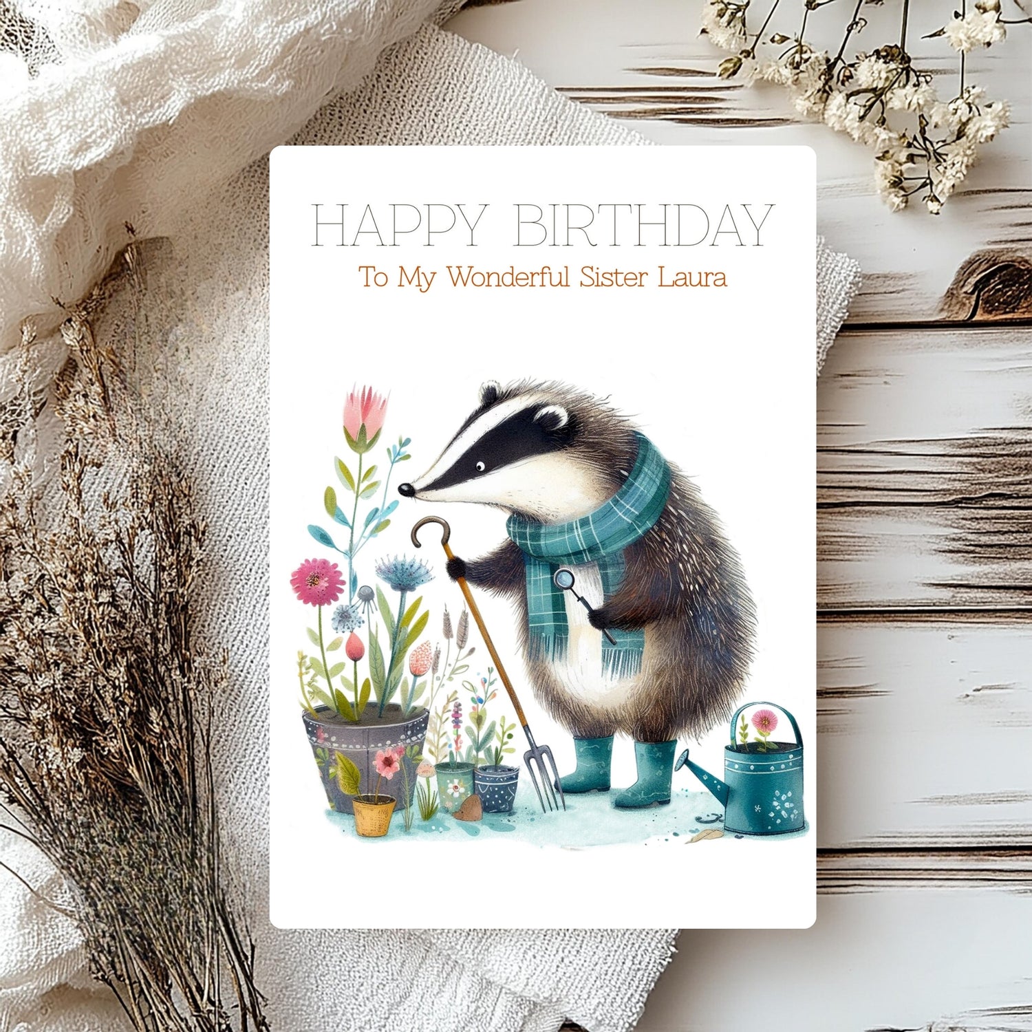 Birthday card with badger illustration and floral elements on a wooden surface.