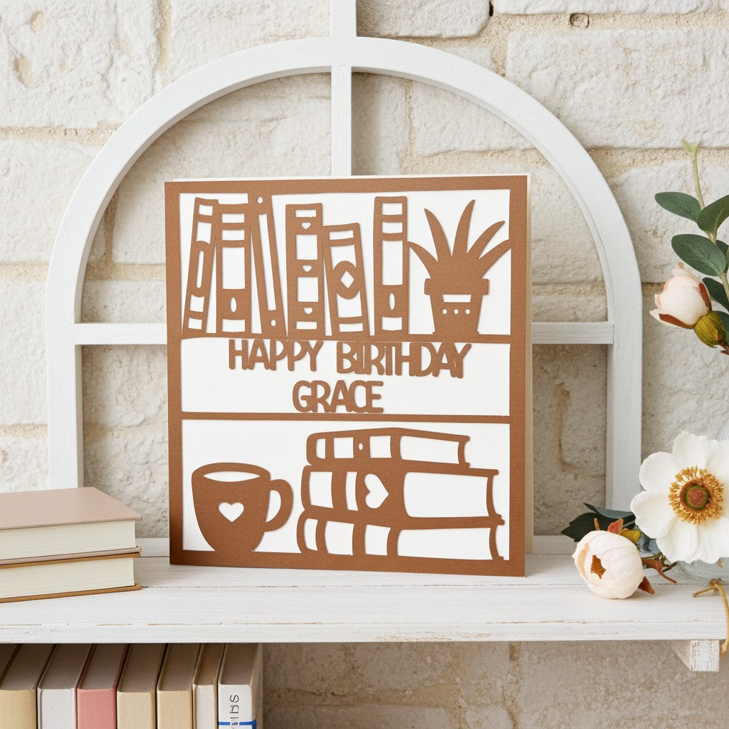 Decorative birthday card with cut-out designs and 'Happy Birthday Grace' text on a shelf.