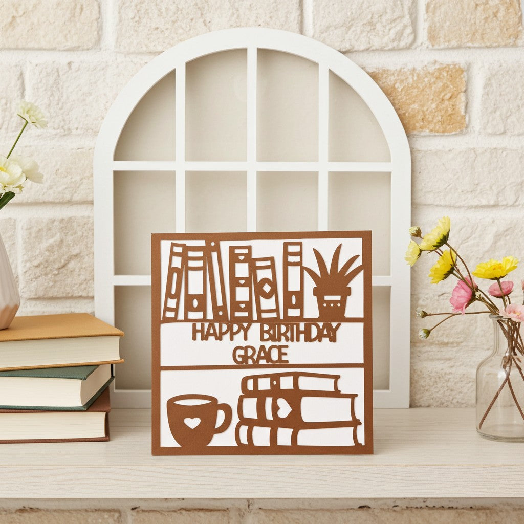 Decorative bookish birthday card with 'Happy Birthday Grace' on a shelf with books and flowers.