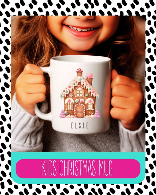 A child holding a white ceramic mug with a cute gingerbread house design and their name 'Elise' printed on it.