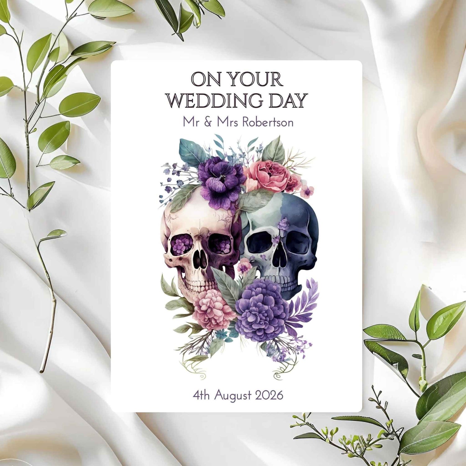 Personalised wedding card with skulls and flowers on a white fabric background