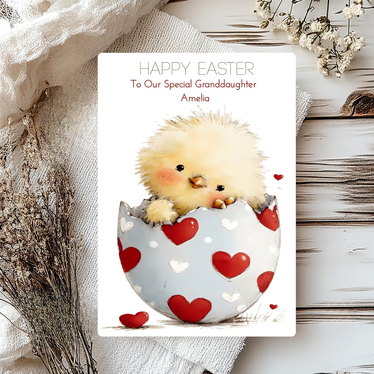 Easter card with a chick in a heart-patterned egg on a wooden surface.