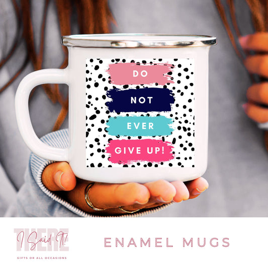 A white ceramic enamel mug with a motivational message 'DO NOT EVER GIVE UP' in a stylized font, accompanied by a spotted print pattern.