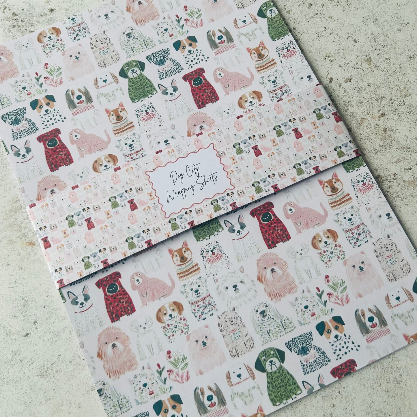Two sheets of wrapping paper with dog pattern on a textured surface