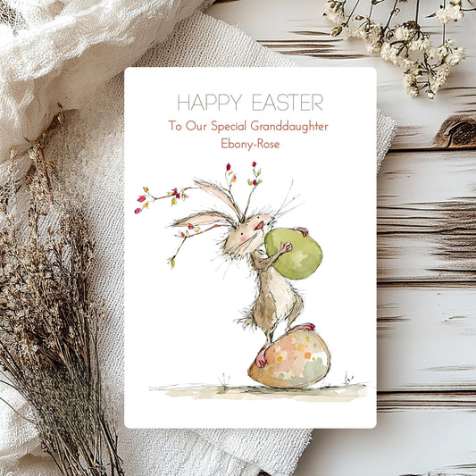 Easter card with a bunny holding an egg on a textured surface with flowers.