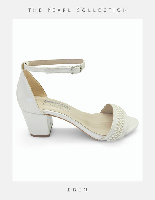 A white Eden low block heel pearl bridal shoe with an ankle strap and open toe design, featuring pearl embellishments.